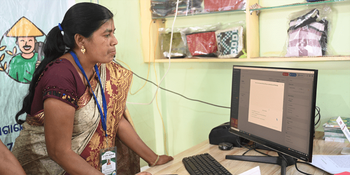 A woman working in front of a computer monitor.