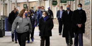 Picture of Chicago Mayor Lori Lightfoot communicating with a food pantry worker while followed by a group of people.