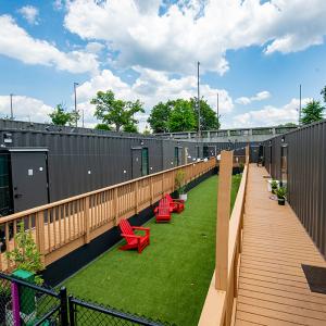 An exterior view of housing and outdoor seating as part of The Melody, a shipping container housing community in Atlanta. It is built for an occupied by hard-to-reach homeless populations as part of the Rapid Housing program.