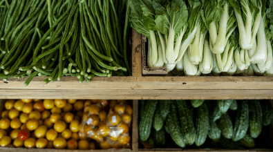 A shelf of vegetables in a market stall.