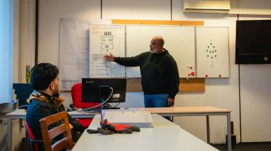 A teacher lecturing to an adult learner.