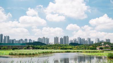 Hwarang Recreation Area park and modern apartment buildings at summer in Ansan, Korea.