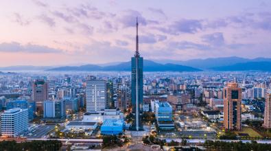 A panorama of Fukuoka tower aerial view from drone at sunset along with Momochi beach, Fukuoka prefecture, Japan.