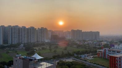 Image of orange sunset with cityscape of Ghaziabad urban sprawl, India viewed from residential balcony.